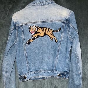 Jean jacket with tiger embroidered patch on the back.